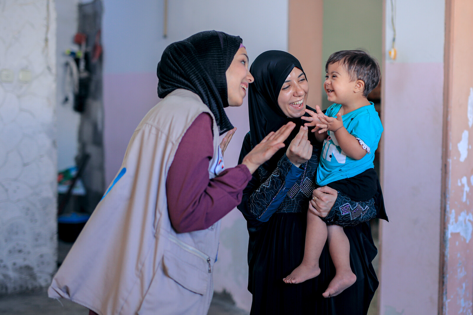 Helferin von Handicap International mit Mutter und Kind in Gaza 
