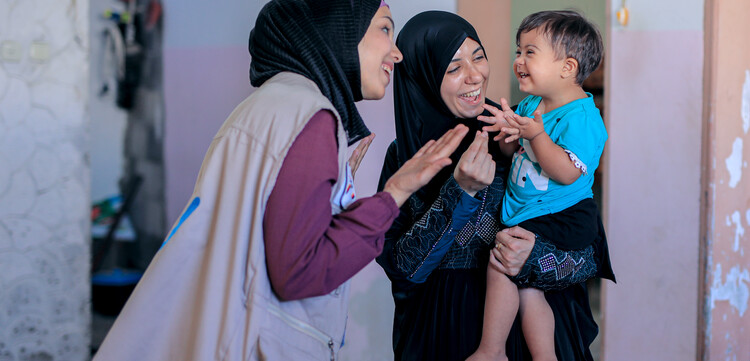 Helferin von Handicap International mit Mutter und Kind in Gaza Helferin von Handicap International mit Mutter und Kind in Gaza