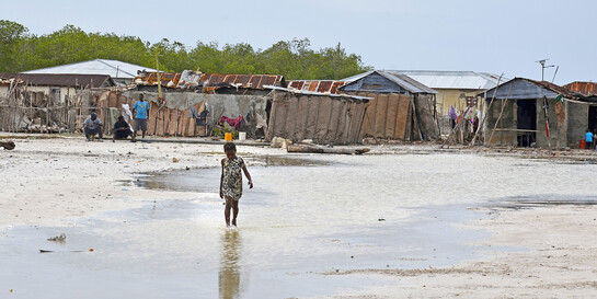 Ein Mädchen läuft nach einer Naturkatastrophe in Haiti durchs Wasser