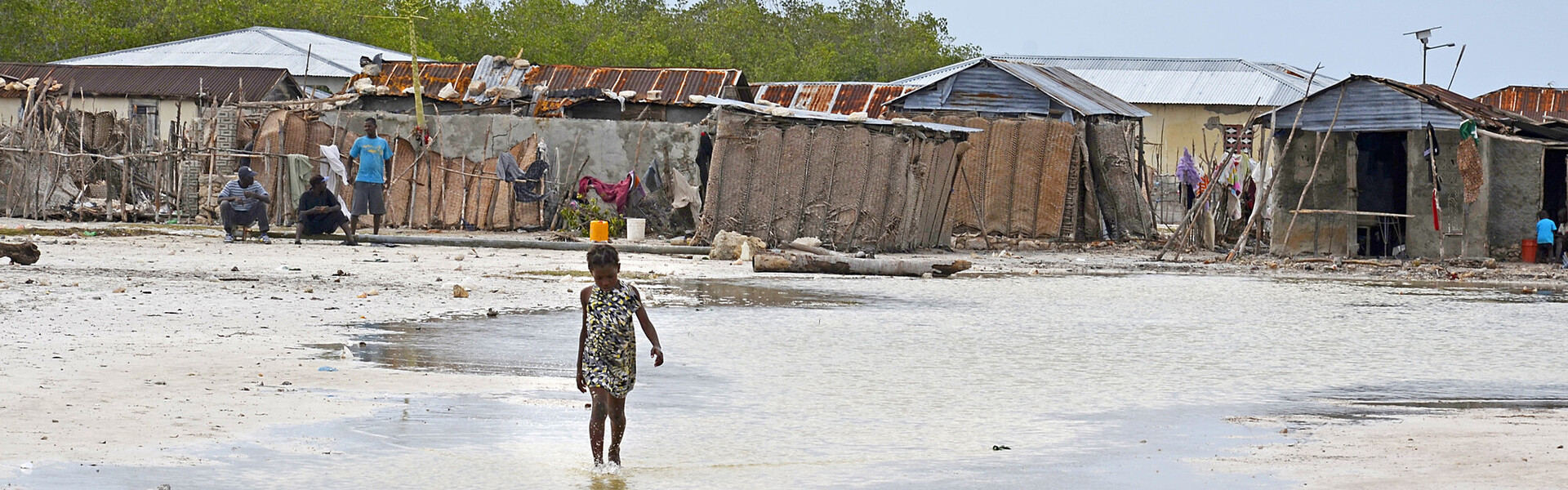 Ein Mädchen läuft nach einer Naturkatastrophe in Haiti durchs Wasser