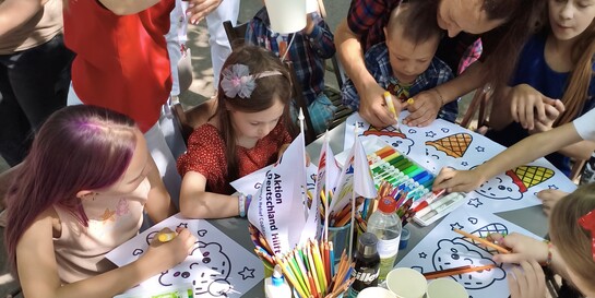 Kinder in der Ukraine malen zusammen mit Helferinnen von Malteser International und finden so Entlastung