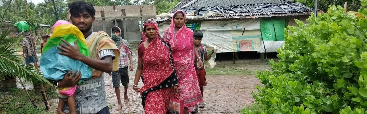 Eine Familie in Bangladesch rettet sich nach dem Zyklon Amphan in eine sichere, trockene Unterkunft 