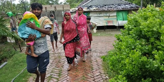 Eine Familie in Bangladesch rettet sich nach dem Zyklon Amphan in eine sichere, trockene Unterkunft 