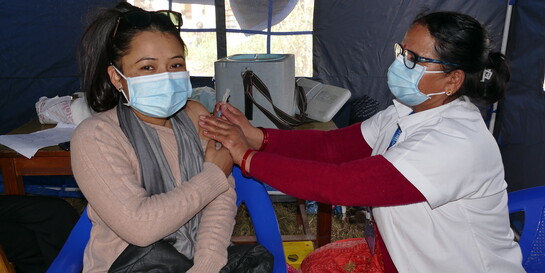 Eine Ärztin in Nepal impft eine Frau