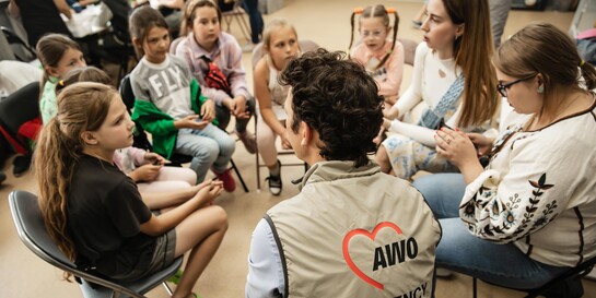 Ein Helfer von AWO International spricht mit einer Gruppe von Kindern