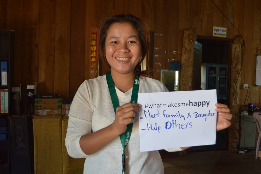 Nam Rom hält einen Zettel in die Luft mit der Aufschrift "#WhatMakesMeHappy - My Family, Daughter and help others"