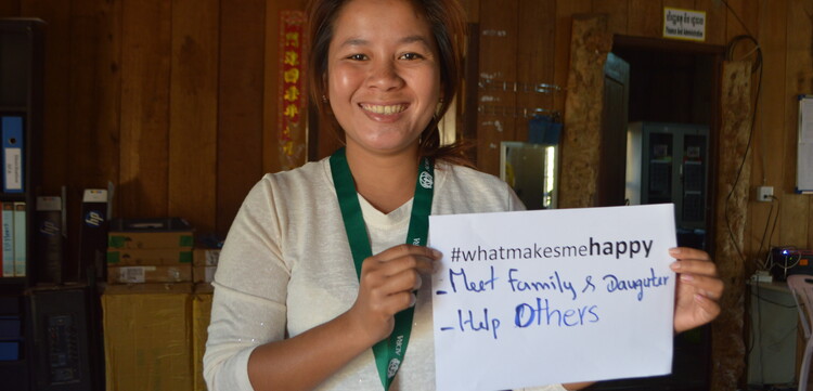 Nam Rom hält einen Zettel in die Luft mit der Aufschrift "#WhatMakesMeHappy - My Family, Daughter and help others"