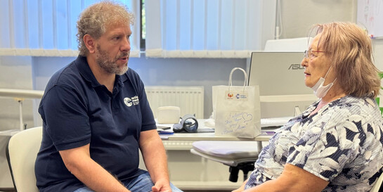 Ein Mitarbeiter von action medeor spricht mit einer herzkranken Frau