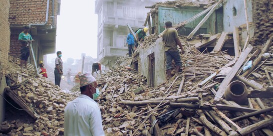 Menschen stehen nach dem Erdbeben Nepal 2015 in den Trümmern (Archivfoto)