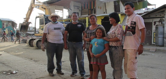 Betroffene des Erdbebens in Ecuador stehen vor zerstörten Gebäuden.