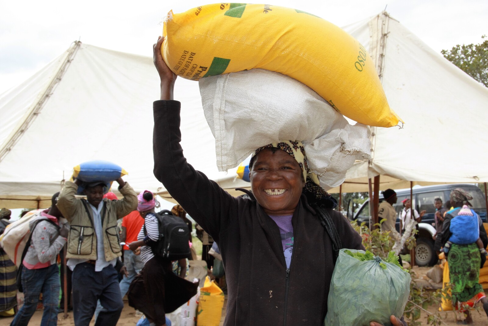 Eine ältere Frau hat ihre Ration an Mehl und Reis erhalten. So kann sie ihre Familie einen Monat lang ernähren.