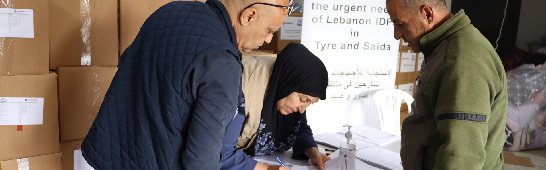 Drei Helfende bei der Verteilung von Hilfsgütern