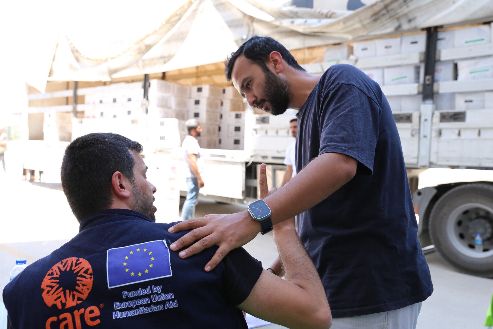 Vural (rechts) mit einem Teamkollegen von CARE vor einem LKW mit Hilfsgütern im Erdbebengebiet Türkei/Syrien