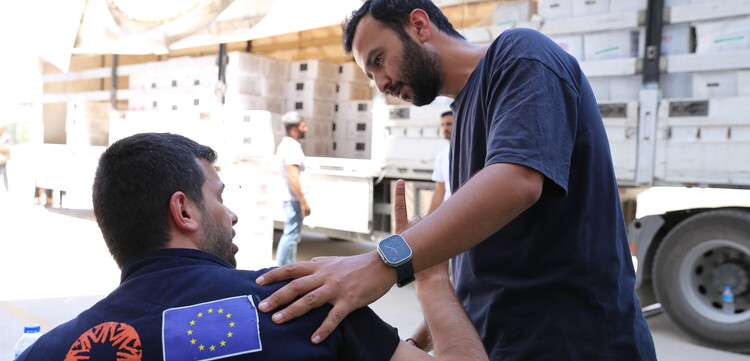 Vural (rechts) mit einem Teamkollegen von CARE vor einem LKW mit Hilfsgütern im Erdbebengebiet Türkei/Syrien