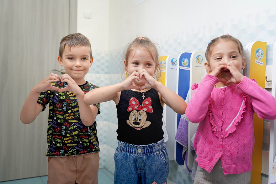 Ein Junge und zwei Mädchen aus der Ukraine formen ein Herz mit ihren Händen Ein Junge und zwei Mädchen aus der Ukraine formen ein Herz mit ihren Händen
