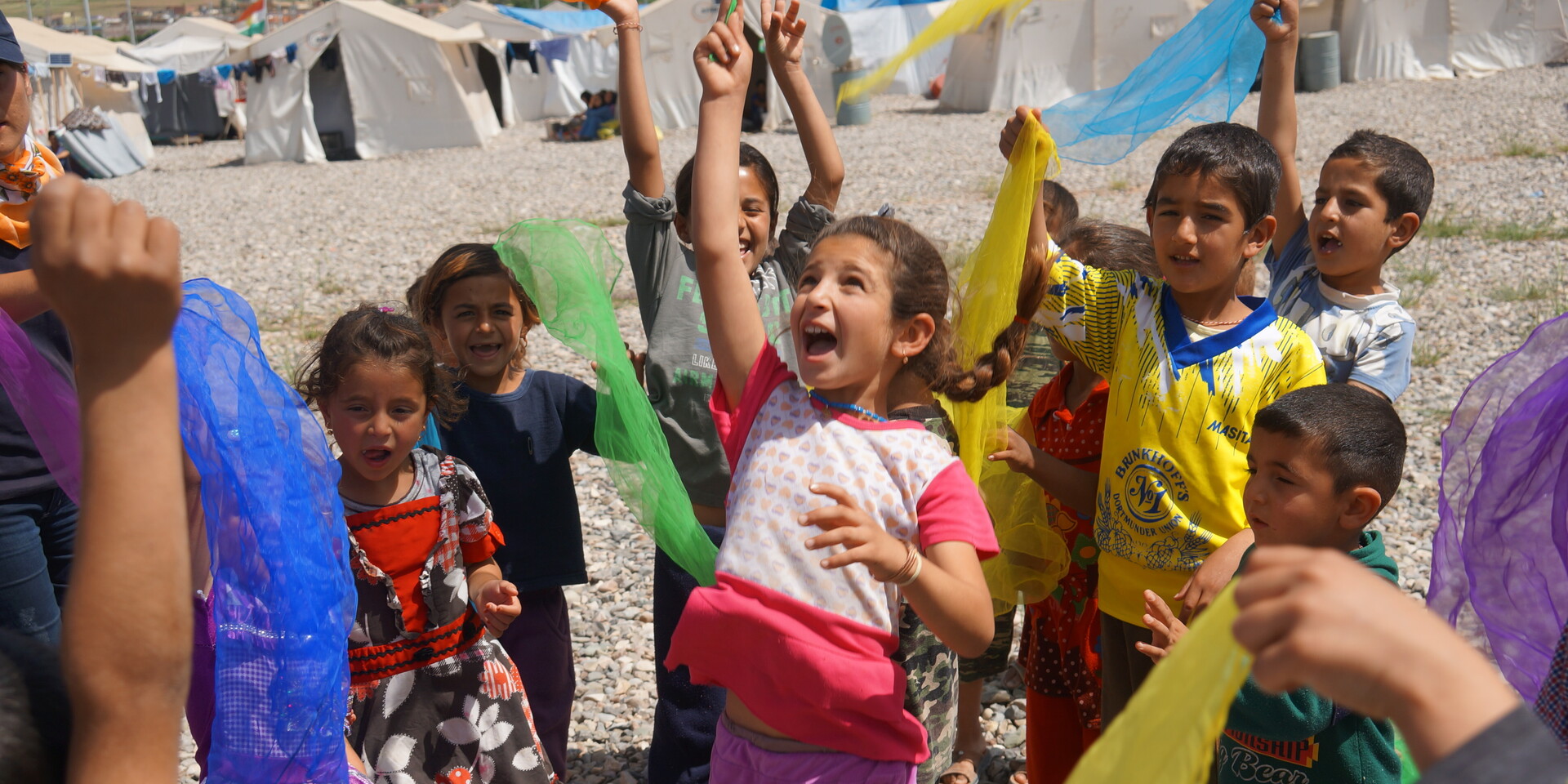 Eine Gruppe von Kindern aus dem Irak beim Spielen mit bunten Tüchern Eine Gruppe von Kindern aus dem Irak beim Spielen mit bunten Tüchern