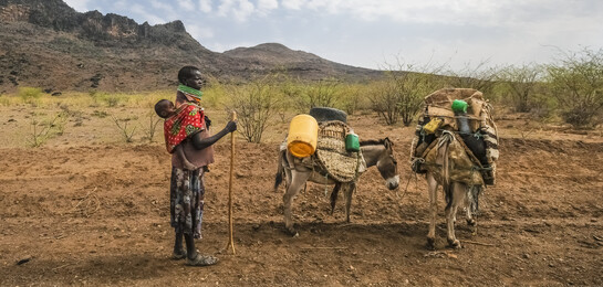 In Kenia steht ein Mann in der vertrockneten Landschaft.