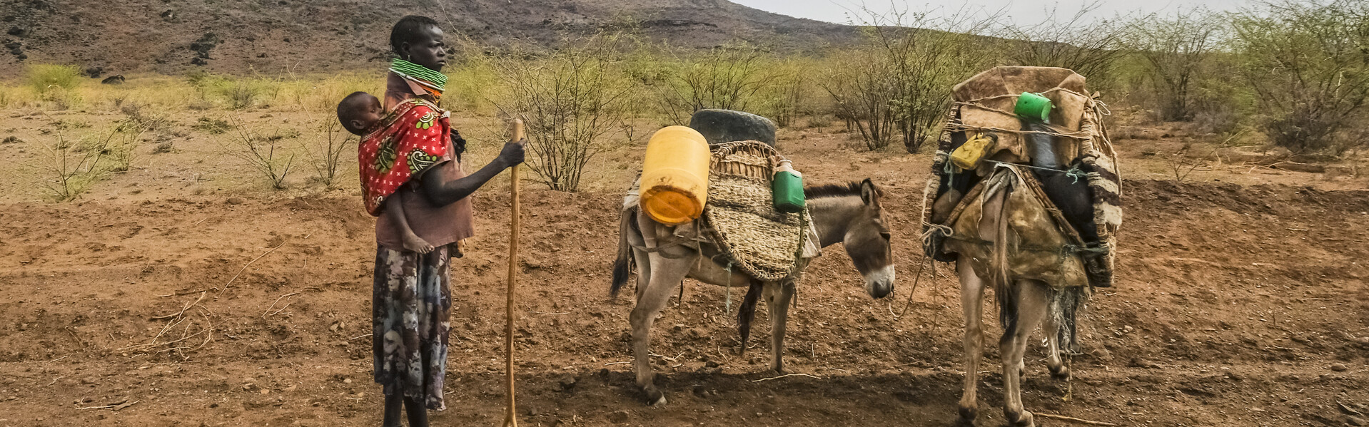 In Kenia steht ein Mann in der vertrockneten Landschaft.