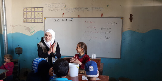 Eine Helferin zeigt Kindern in einer Schule in Idlib, wie man sich richtig die Hände wäscht 