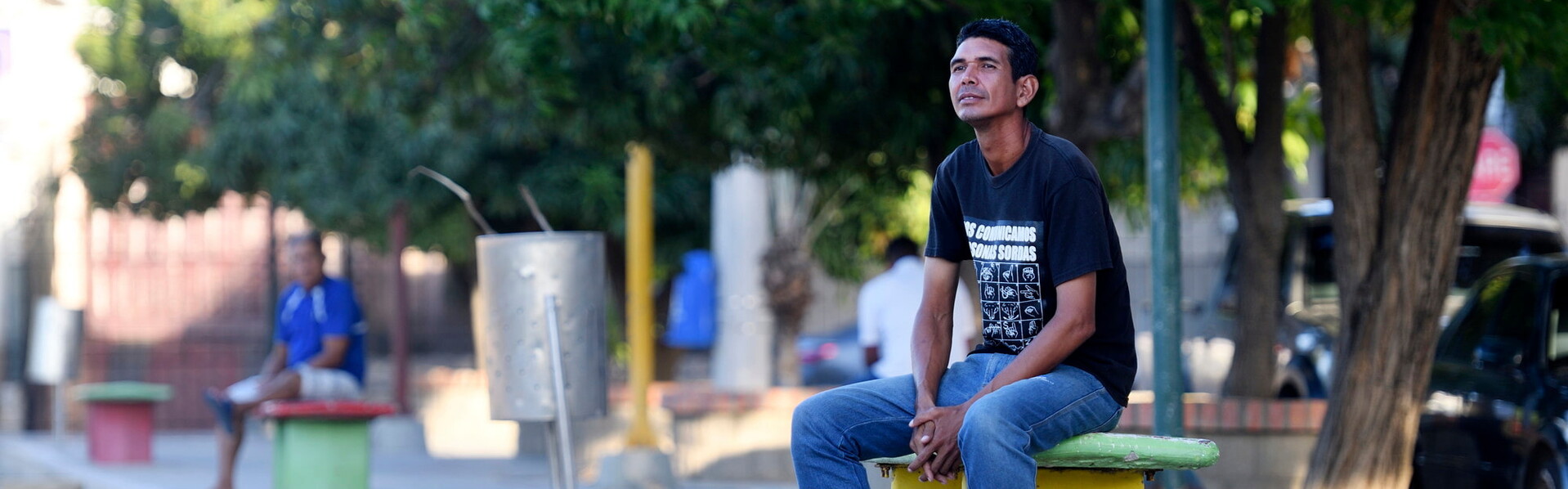 Venezuela zählt zu den artenreichsten Ländern der Welt und ist zugleich von einer anhaltenden humanitären Krise geprägt. Ein Mann sitzt auf einer Bank an einem Straßenrand in Venezuela und schaut in die Ferne