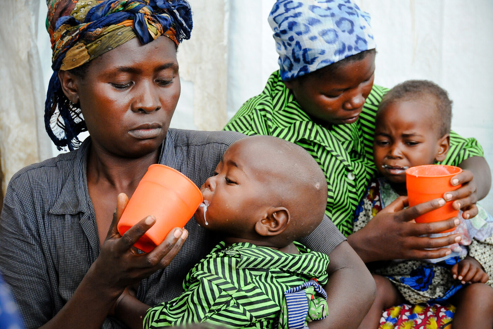 Zwei Frauen füttern ihre kleinen Kinder. Durch eine schwere Dürre im Kongo sind viele Menschen schwer unterernährt.