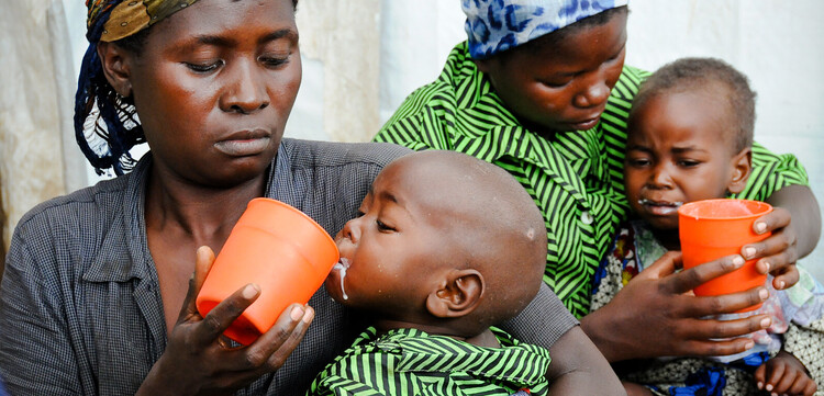 Zwei Frauen füttern ihre kleinen Kinder. Durch eine schwere Dürre im Kongo sind viele Menschen schwer unterernährt. Zwei Frauen füttern ihre kleinen Kinder. Durch eine schwere Dürre im Kongo sind viele Menschen schwer unterernährt.