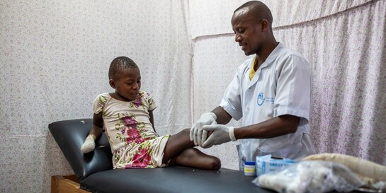 Ein Physiotherapeut von Handicap International untersucht Kizubizo aus dem DR Kongo, die beide Beine wegen eines Rebellenangriffs verloren hat