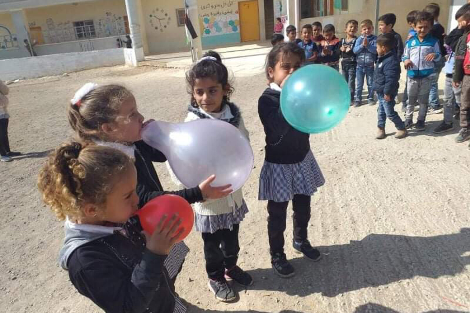 Eine Gruppe von Mädchen im Westjordanland bläst bunte Ballons auf