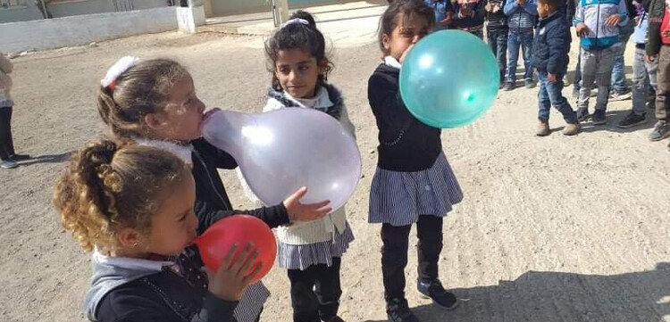 Eine Gruppe von Mädchen im Westjordanland bläst bunte Ballons auf