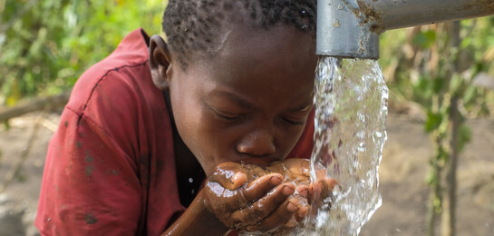 Ein Kind in Uganda am Wasserbrunnen