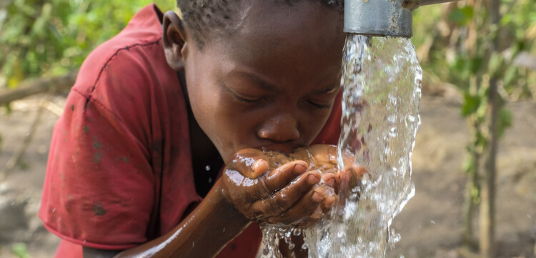 Ein Kind in Uganda am Wasserbrunnen