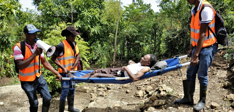 Katastrophenübung auf Haiti: Männer in Warnwesten transportieren eine Frau auf einer Krankenbahre Katastrophenübung auf Haiti: Männer in Warnwesten transportieren eine Frau auf einer Krankenbahre