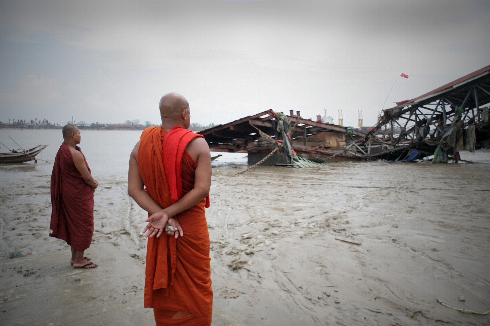 In Myanmar sind häufig die Küstengebiete von Überschwemmungen betroffen. Mönche betrachten nach einer schweren Flut die Zerstörung im Hafen.