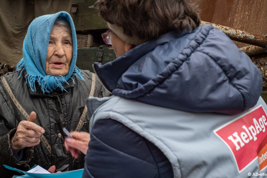 Eine Helferin von HelpAge spricht mit einer älteren Frau