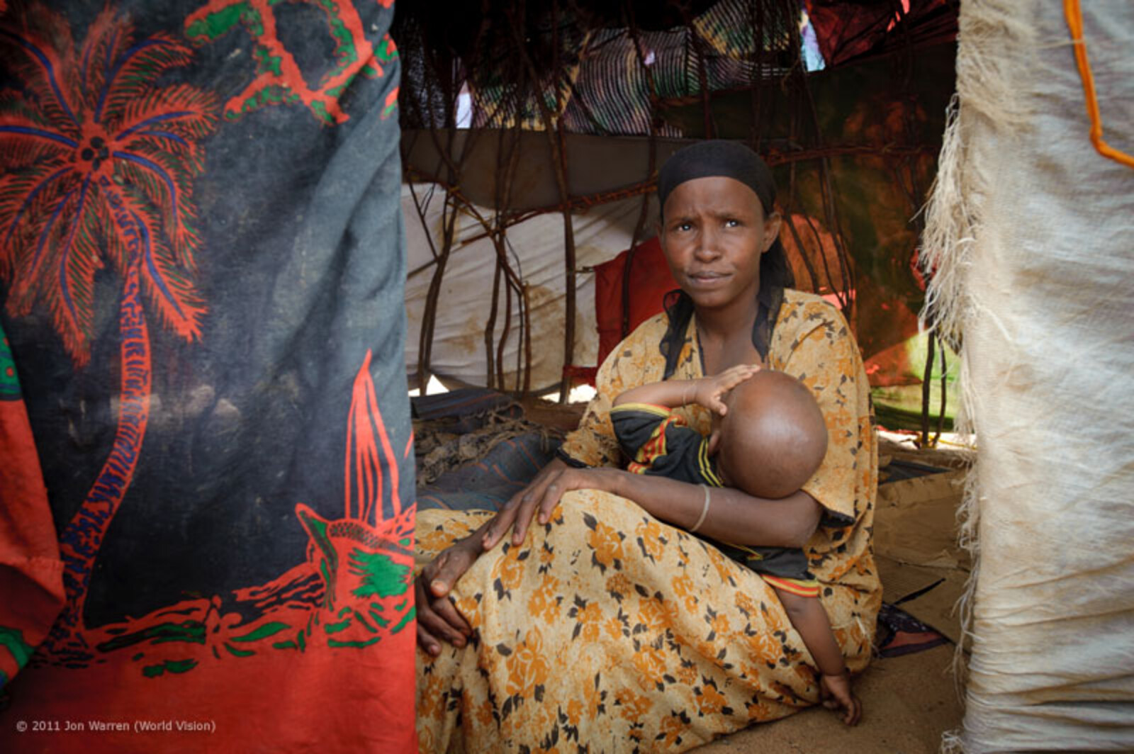 Isnino hält ihr Baby Suleiman im Arm, während sie erzählt, dass sie keine Nahrungsmittel mehr besitzt. Sie muss nun bei Verwandten um etwas zu essen betteln. Sie ist besorgt über ihre Zukunft und die ihrer Familie. Wie viele Somalier ist auch sie vor der