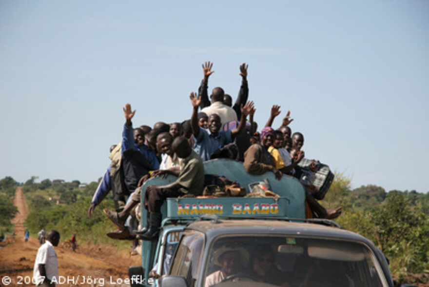 Flut Afrika: winkende Menschen auf LKW