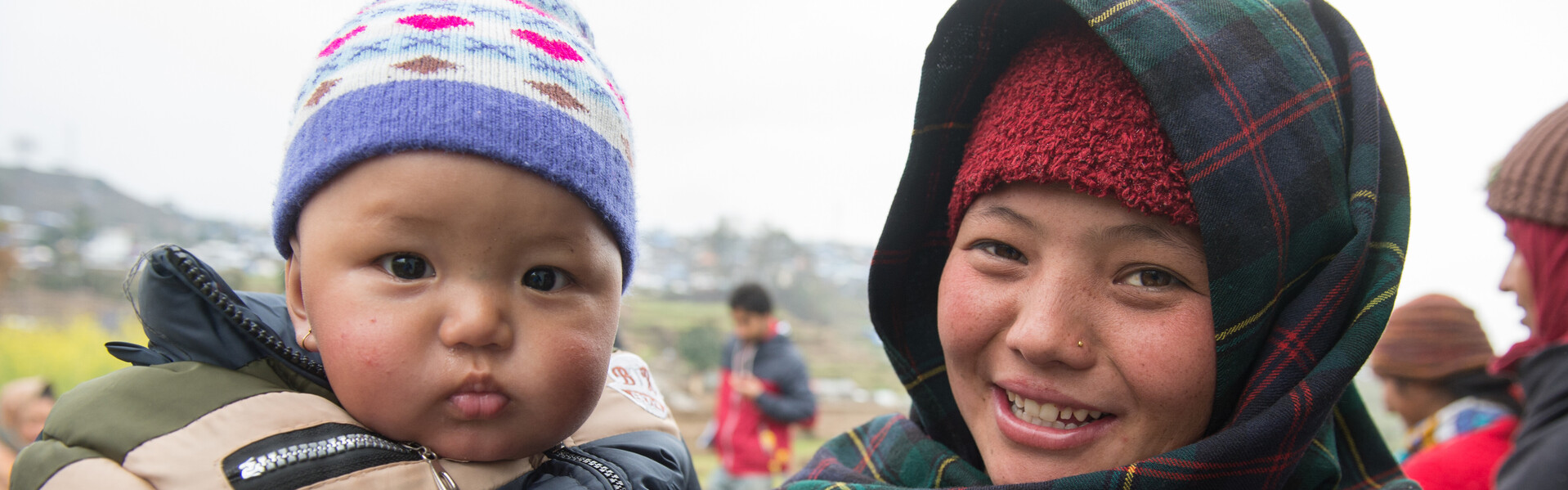 Eine Frau hält ein Kind im Arm in Nepal.