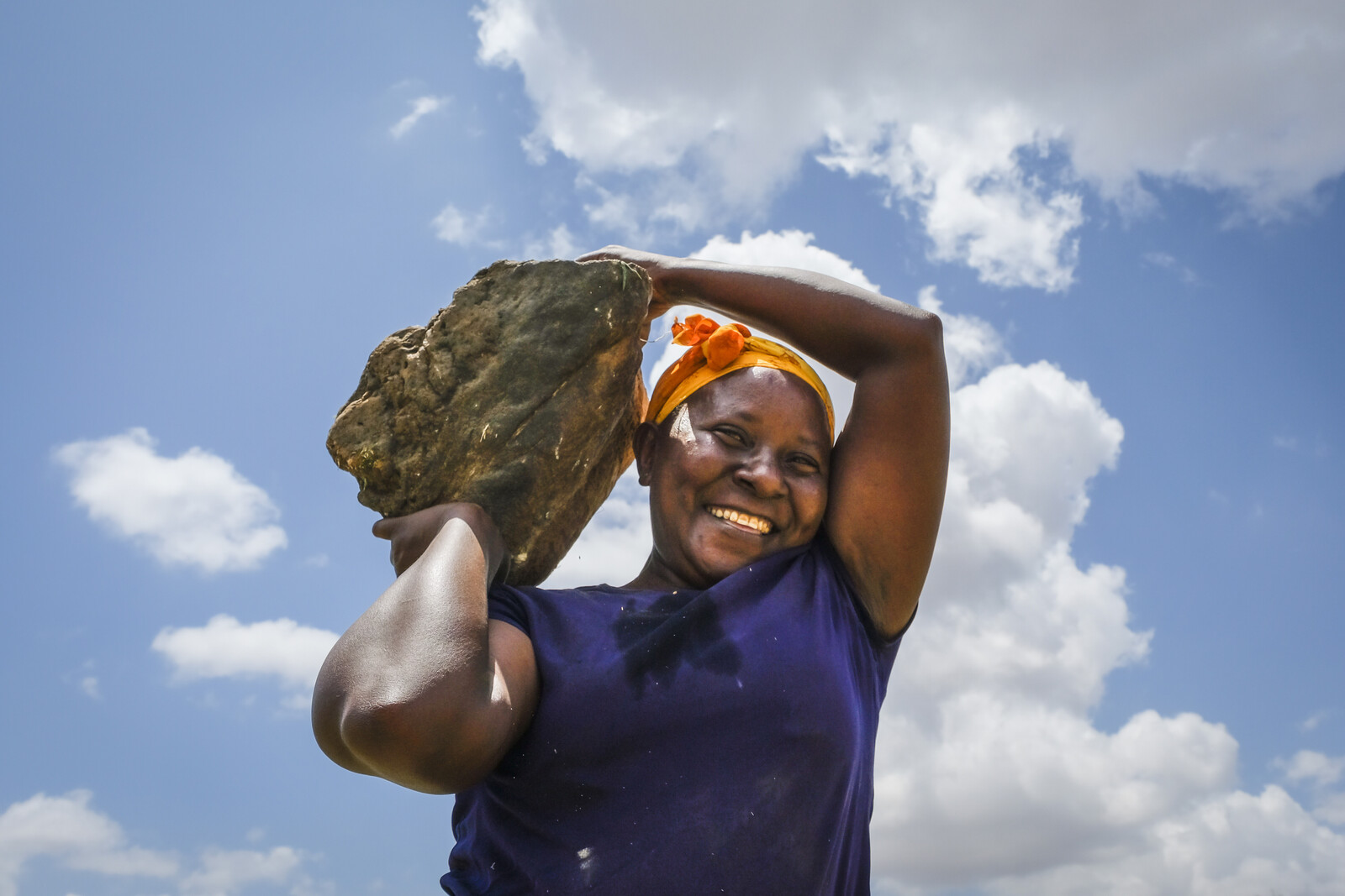 Hilfsprojekt in Kenia: Eine Frau trägt einen Stein