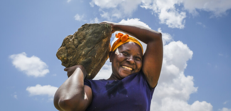 Hilfsprojekt in Kenia: Eine Frau trägt einen Stein