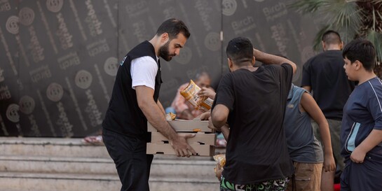 Ein Helfer verteilt Lebensmittel an Menschen im Libanon