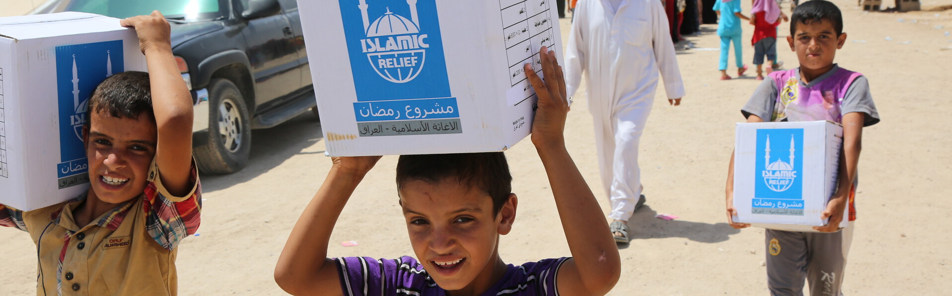 Children carry aid packages home Children carry aid packages home