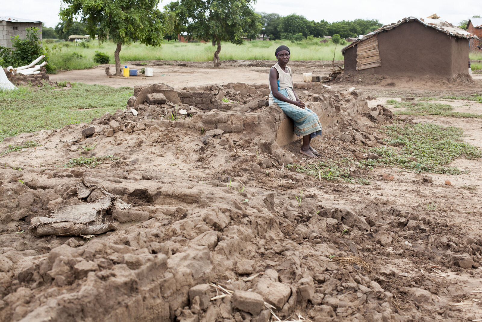 Eine Frau in Malawi vor ihrem durch Zyklon Idai zerstörten Haus 