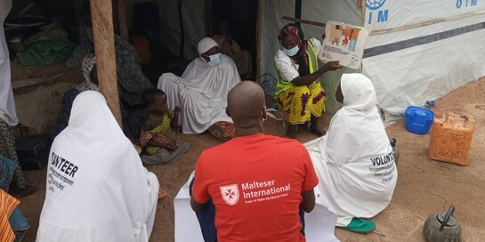 Helfer der Malteser klären in einem Flüchtlingscamp in Nigeria über Cholera auf