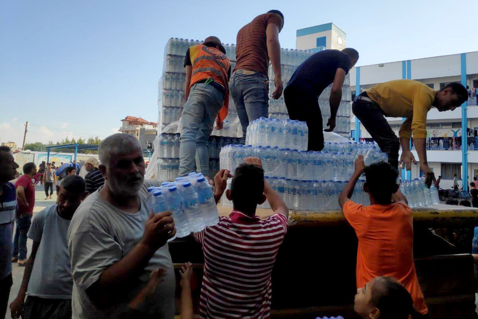 Helfer verteilen Trinkwasser an vertriebene Menschen im Gazastreifen