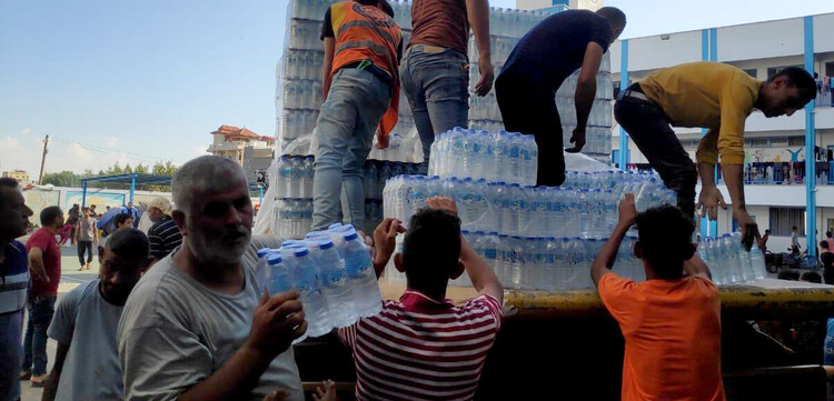 Helfer verteilen Trinkwasser an vertriebene Menschen im Gazastreifen Helfer verteilen Trinkwasser an vertriebene Menschen im Gazastreifen
