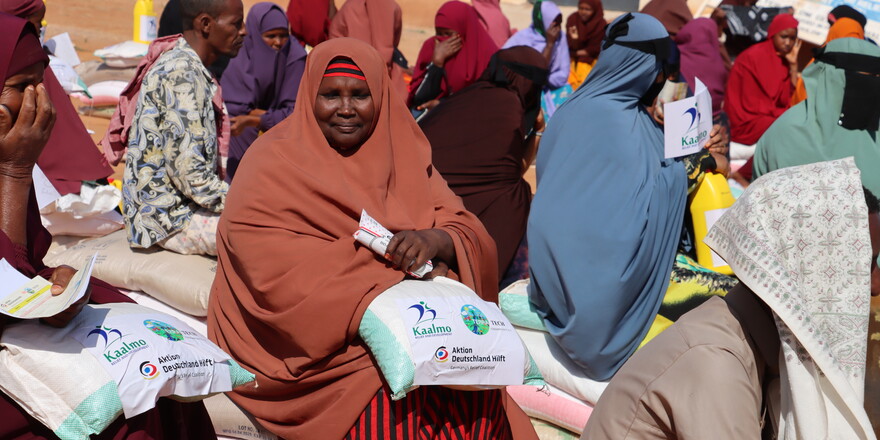 Eine Frau aus Somalia mit Hilfpaketen, die sie erhalten hat