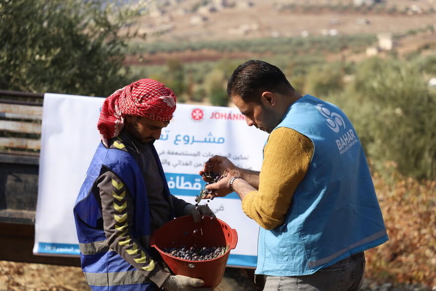 Ein Helfer teilt an einen Mann in Syrien Nahrung aus