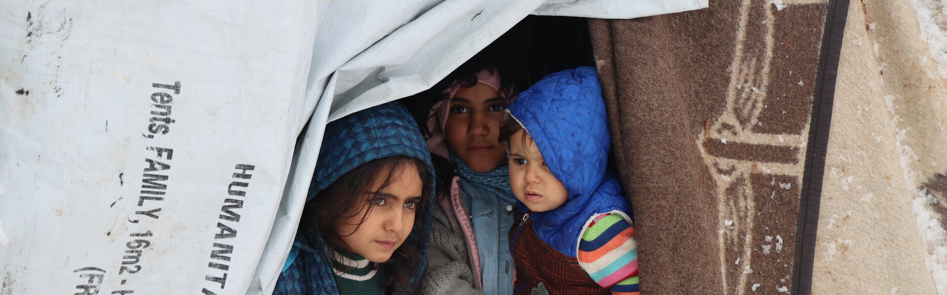 Drei Kinder in einem Zeltlager in Syrien