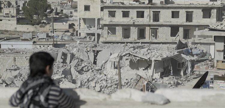 Ein Kind in Syrien schaut auf zerstörte Häuser Ein Kind in Syrien schaut auf zerstörte Häuser