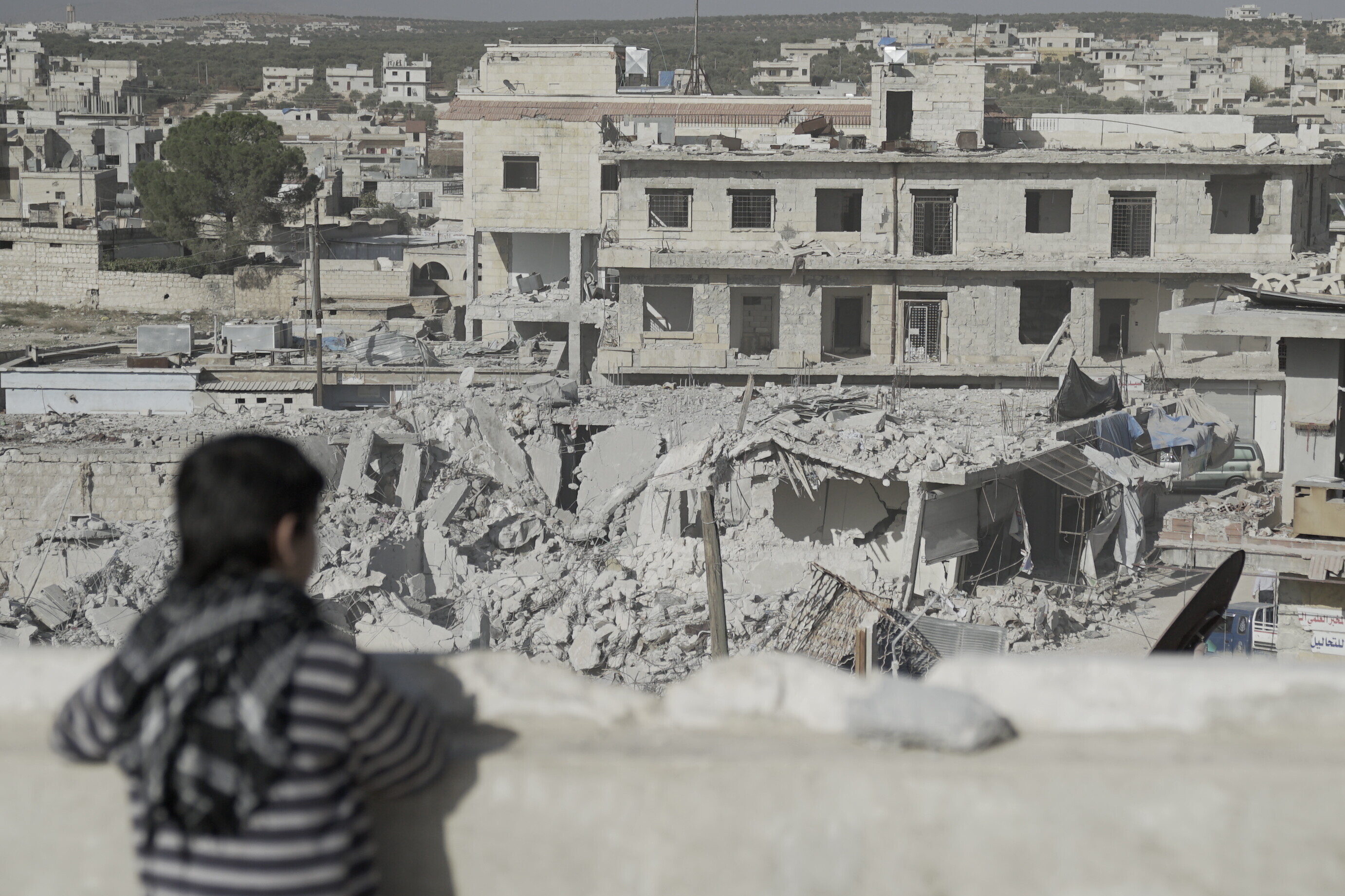 Ein Kind in Syrien schaut auf zerstörte Häuser Ein Kind in Syrien schaut auf zerstörte Häuser